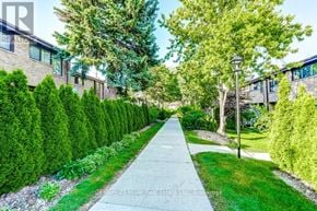 Mississauga (Sheridan) townhouse for rent - A residential street with houses on both sides and a sidewalk in the foreground.