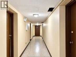 Windsor apartment for rent - A long hallway with doors on both sides and a light on the ceiling.