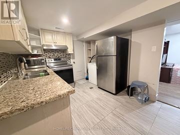 Toronto (Wexford-Maryvale) apartment for rent - A kitchen with a granite counter top and a refrigerator.