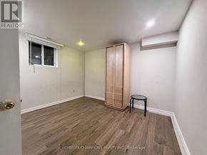 Toronto (Wexford-Maryvale) apartment for rent - A room with a wooden floor and a small table.