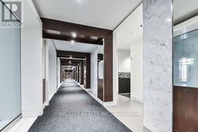 Toronto (Islington-City Centre West) condo for rent - A long hallway with a marble wall on the side and a carpeted floor.