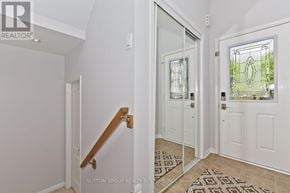 Milton (Co Coates) townhouse for rent - A hallway with a wooden staircase and white walls.