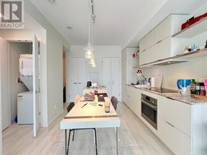 Toronto (Church-Yonge Corridor) condo for rent - A kitchen with white cabinets and a table with chairs.