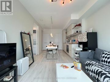 Toronto (Church-Yonge Corridor) condo for rent - A living room with a black and white checkered couch, a television, a coffee table, and a dining table with chairs.