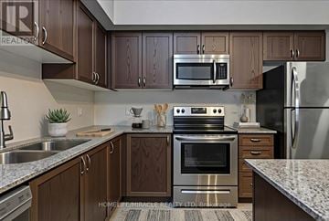 New Tecumseth (Alliston) condo for rent - A kitchen with brown cabinets and stainless steel appliances.