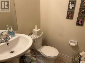 Vaughan (Patterson) townhouse for rent - A bathroom with a toilet, sink, and wall art.