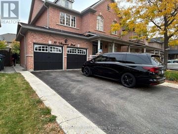 Brampton (Bram East) apartment for rent - A black SUV is parked in front of a brick house with a garage.
