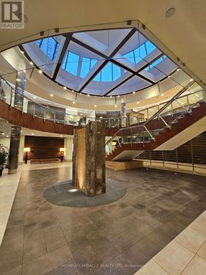 Mississauga (City Centre) condo for rent - A large atrium with a spiral staircase and a skylight.
