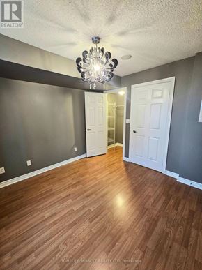 Mississauga (City Centre) condo for rent - A room with wooden floors and a chandelier.