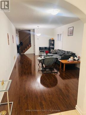 Brampton (Northwest Brampton) apartment for rent - A living room with a black couch and a glass table.