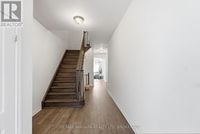 Thorold (Rolling Meadows) townhouse for rent - A hallway with a staircase and a light on the ceiling.