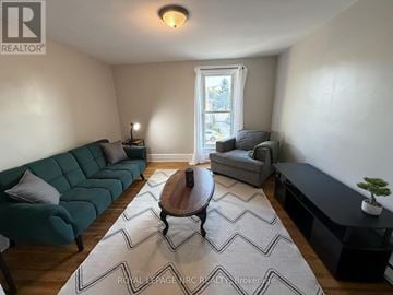 Welland (Welland Downtown) duplex for rent - A living room with a green couch and a wooden coffee table.