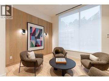 Burnaby apartment for rent - A living room with a large window, a round table, and a painting on the wall.