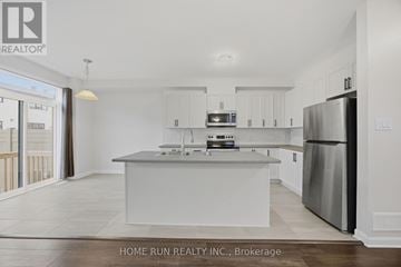 Ottawa townhouse for rent - A modern kitchen with white cabinets and stainless steel appliances.