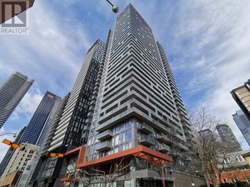Toronto (Church-Yonge Corridor) condo for rent - A tall building with a sign that says "HOMELESS WORLD" on it.