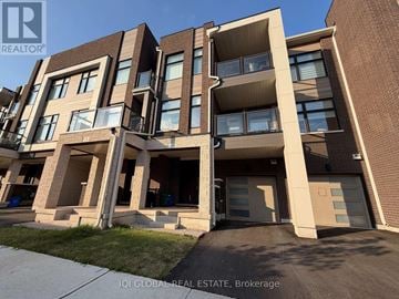 Oakville (Jm Joshua Meadows) townhouse for rent - A modern apartment building with balconies and garage doors.