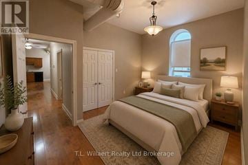 Tillsonburg multi-family for rent - A bedroom with a large bed and a window.