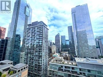 Toronto (Waterfront Communities) condo for rent - A cityscape with skyscrapers and a building with the text "REALONE REALTOR" on it.