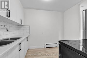 London East (East H) multi-family for rent - A kitchen with white cabinets and a black counter top.