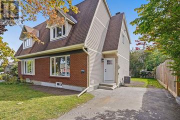 Ottawa apartment for rent - A house with a brown roof and a white door is surrounded by a grassy area and trees.