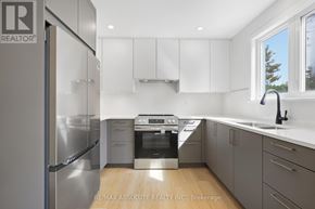 Ottawa apartment for rent - A modern kitchen with a stainless steel refrigerator and white cabinets.
