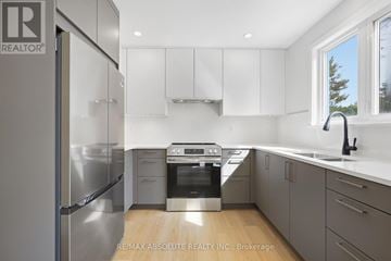 Ottawa apartment for rent - A modern kitchen with a stainless steel refrigerator and white cabinets.