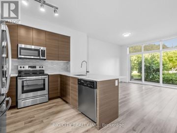 Toronto (Henry Farm) townhouse for rent - A modern kitchen with a stainless steel dishwasher and wooden cabinets.