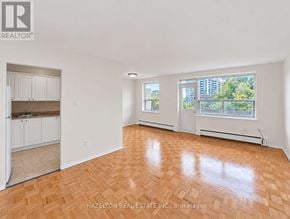 Toronto (Parkwoods-Donalda) condo for rent - A room with wooden flooring and a window overlooking a cityscape.