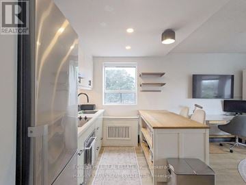 Toronto (Woodbine Corridor) condo for rent - A modern kitchen with stainless steel appliances and a wooden countertop.