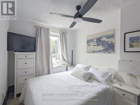 Toronto (Woodbine Corridor) condo for rent - A bedroom with a bed, dresser, and television.