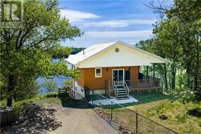 Walford apartment for rent - A yellow house with a deck and a lake in the background.