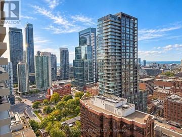 Toronto (Waterfront Communities) condo for rent - A cityscape with tall buildings and a clear sky.
