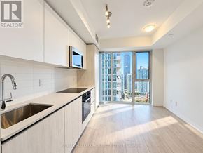 Toronto (Waterfront Communities) condo for rent - A modern kitchen with a view of the city.