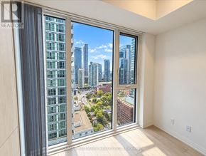 Toronto (Waterfront Communities) condo for rent - A room with a view of a city skyline through a large window.