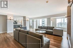 Toronto (Moss Park) condo for rent - A spacious living room with a grey sofa set and a glass table.