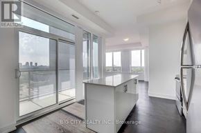 Toronto (Bayview Village) condo for rent - A modern kitchen with a view of the city through the windows.
