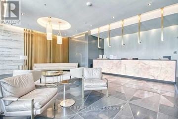 Toronto (Bayview Village) condo for rent - A modern living room with a white sofa and a glass table.
