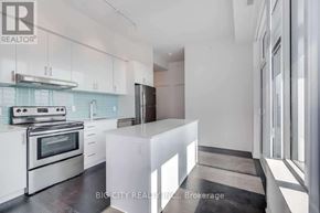Toronto (Bayview Village) condo for rent - A modern kitchen with stainless steel appliances and white cabinetry.