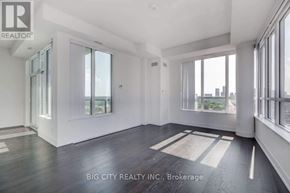 Toronto (Bayview Village) condo for rent - A spacious room with a view of the city skyline through large windows.
