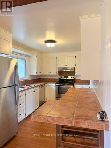 Orangeville apartment for rent - A kitchen with a stainless steel refrigerator and wooden countertops.