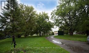 Lincoln (Beamsville) apartment for rent - A tree-lined path in a park with a sign that says "Royal LePage NRC REALTY Brokerage.".