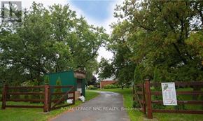 Lincoln (Beamsville) apartment for rent - A green building is behind a gate with a sign that says Royal LePage NRO Realty Brokerage.