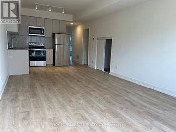 St. Catharines (E. Chester) townhouse for rent - A spacious living room with a kitchen area in the background.