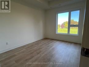 St. Catharines (E. Chester) townhouse for rent - A room with a large window showing a green lawn outside.