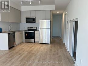 St. Catharines (E. Chester) townhouse for rent - A kitchen with a refrigerator, microwave, and oven.