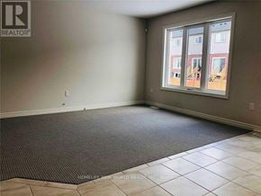 Niagara Falls (Oldfield) townhouse for rent - A room with a carpeted floor and a window showing a building outside.