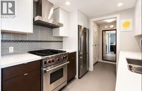 Vancouver apartment for rent - A modern kitchen with stainless steel appliances and wooden cabinets.