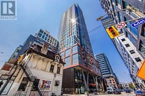 Toronto (Waterfront Communities) condo for rent - A city street with a mix of old and new buildings, with a no parking sign visible.