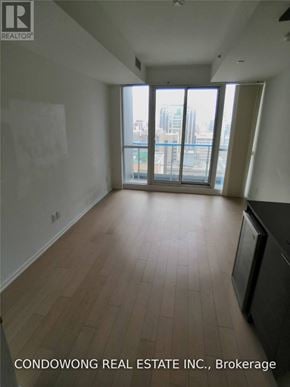 Toronto (Bay Street Corridor) condo for rent - Empty room with a view of the city through the window.