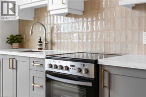 Hamilton apartment for rent - A modern kitchen with a black stove top oven and white cabinets.